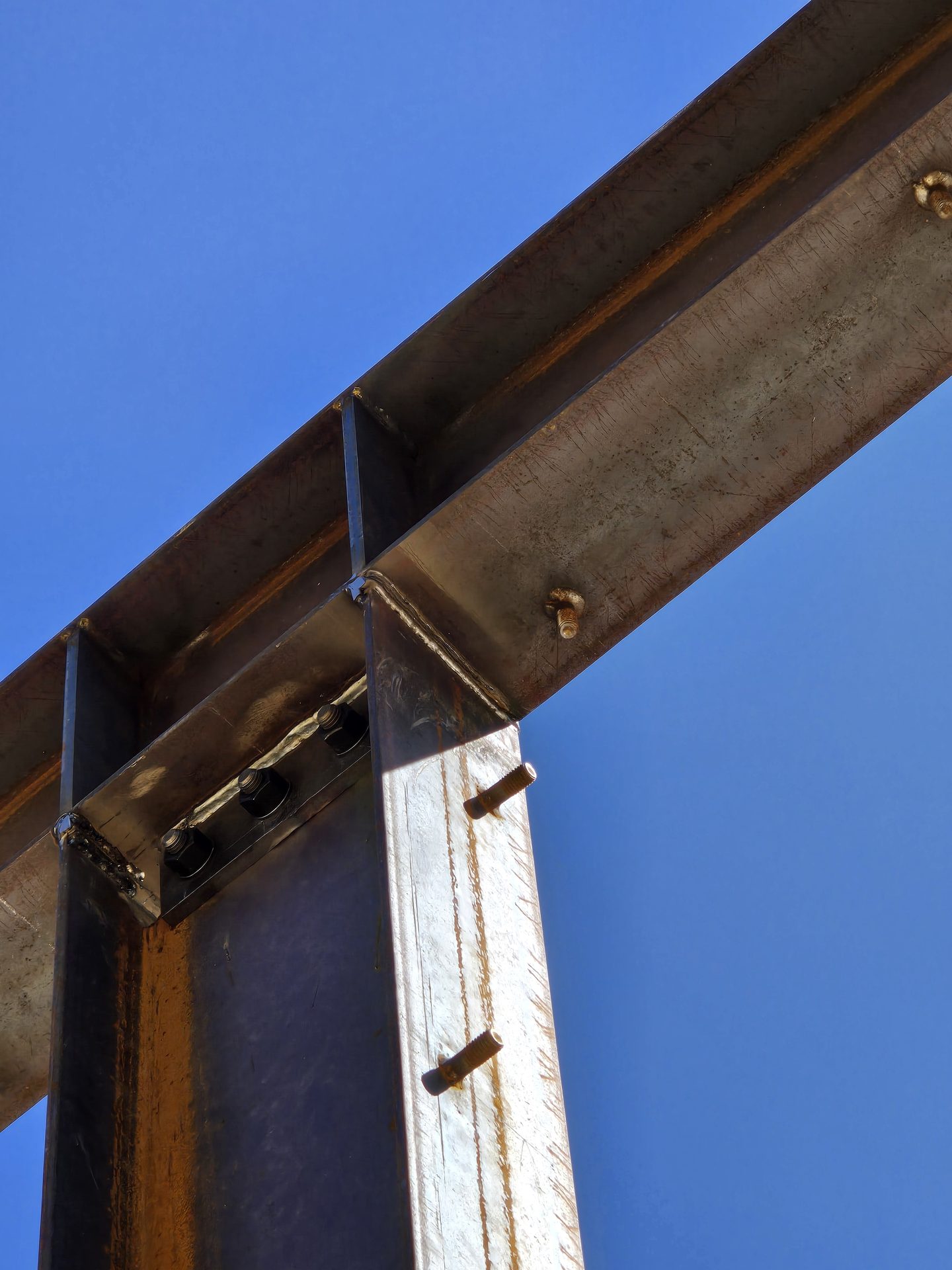 Close-up of bolted moment connection plate against blue Sierra sky
