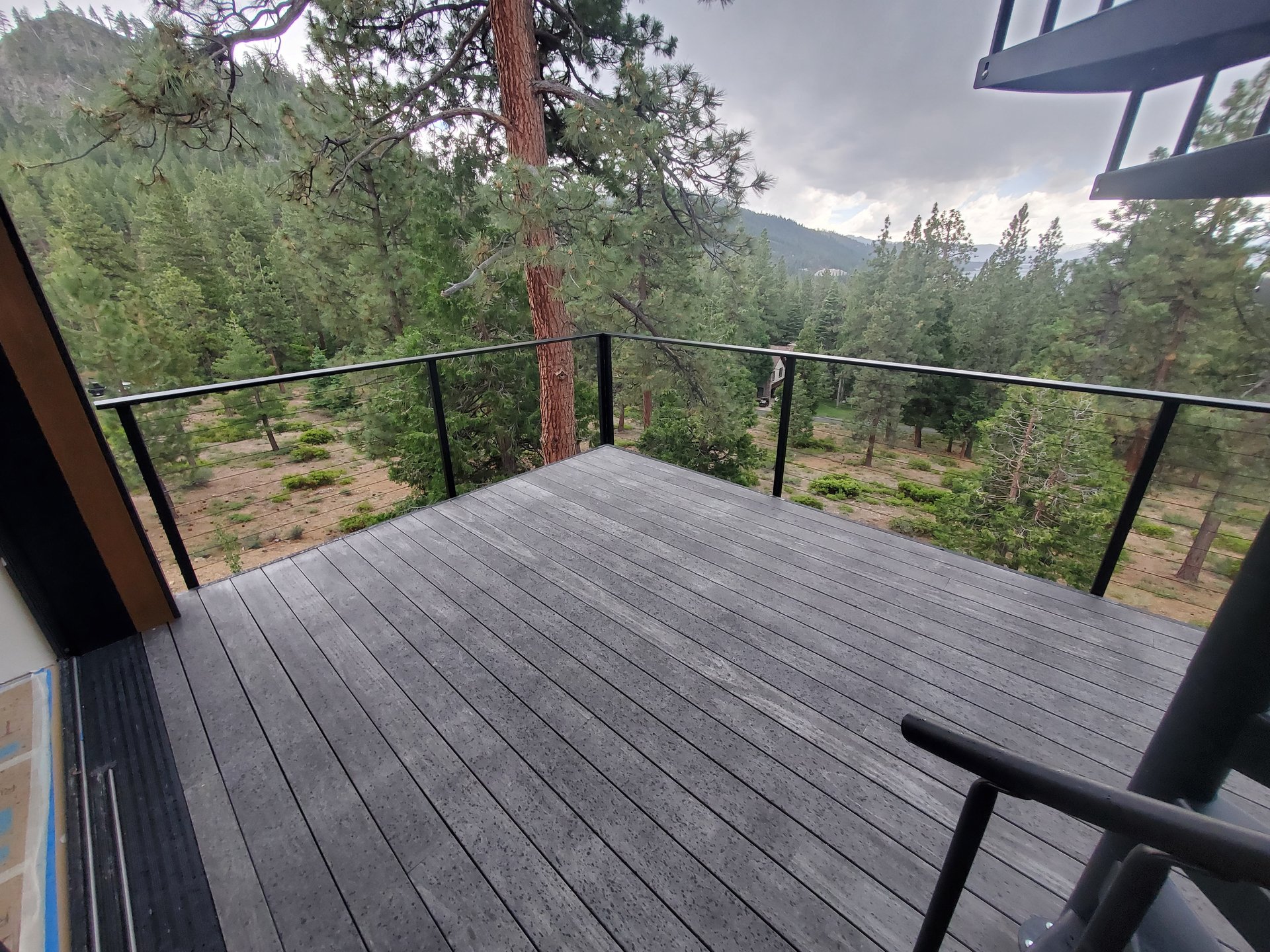 Custom steel cable railing with Sierra pine views
