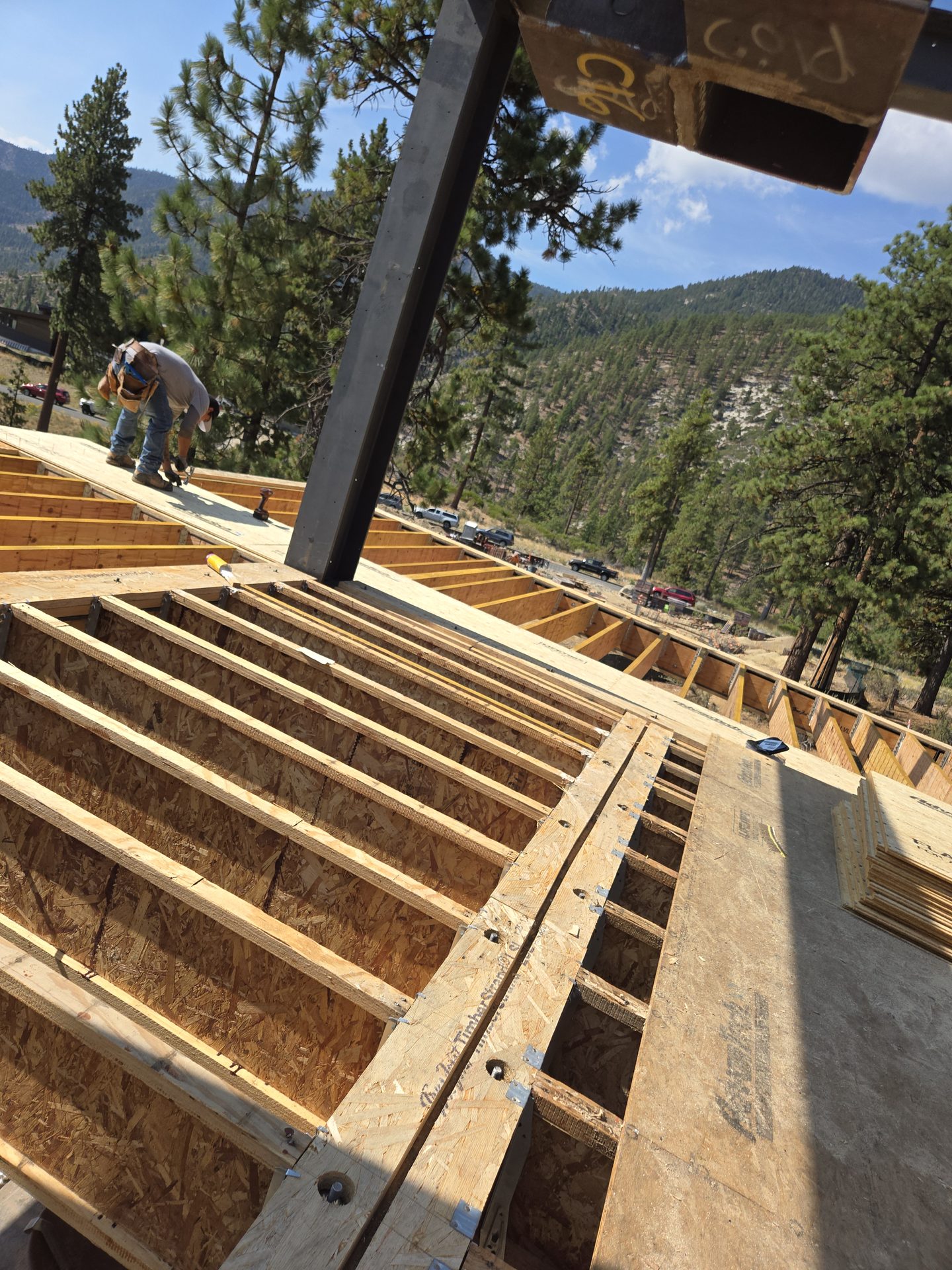 Steel column being lowered into floor joist system at Boulders Bend residence