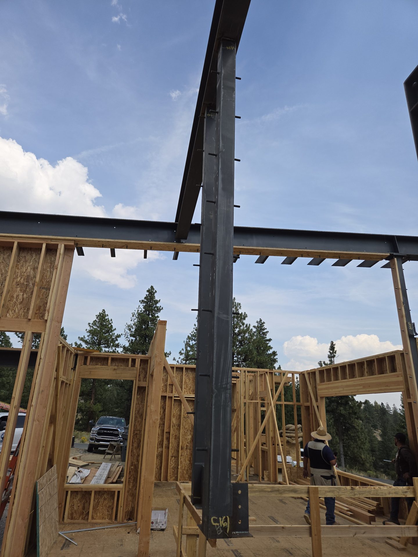 Full-height black steel moment column integrated into custom home framing with mountain views