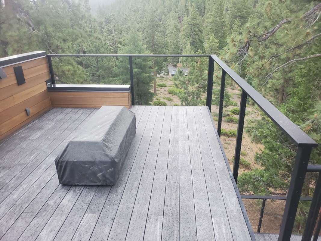 Glass and steel cable railing on an elevated deck overlooking a Sierra Nevada forest at Bogowolski Residence