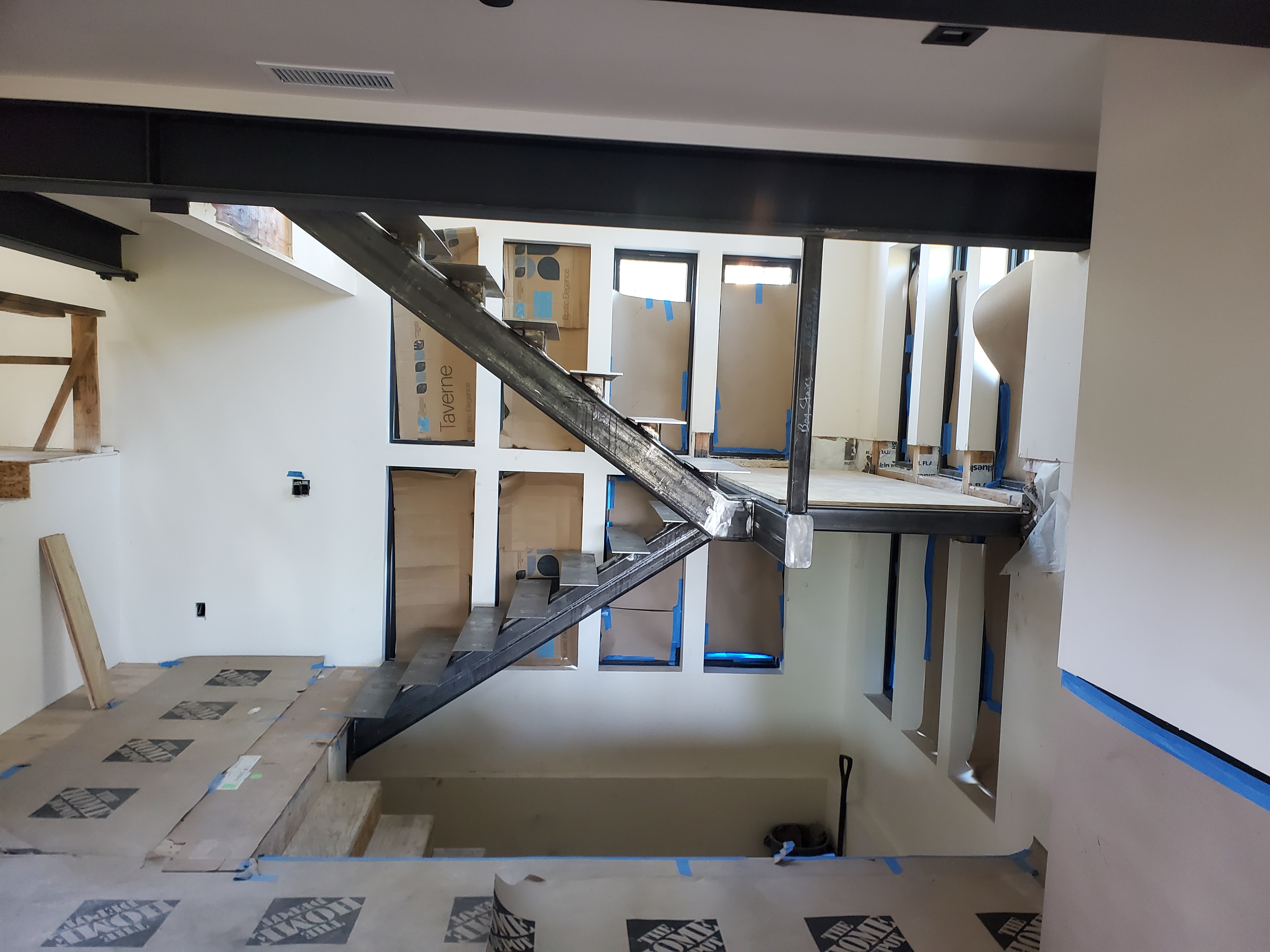 Custom steel staircase with cantilevered treads framed within a Bogowolski Residence build