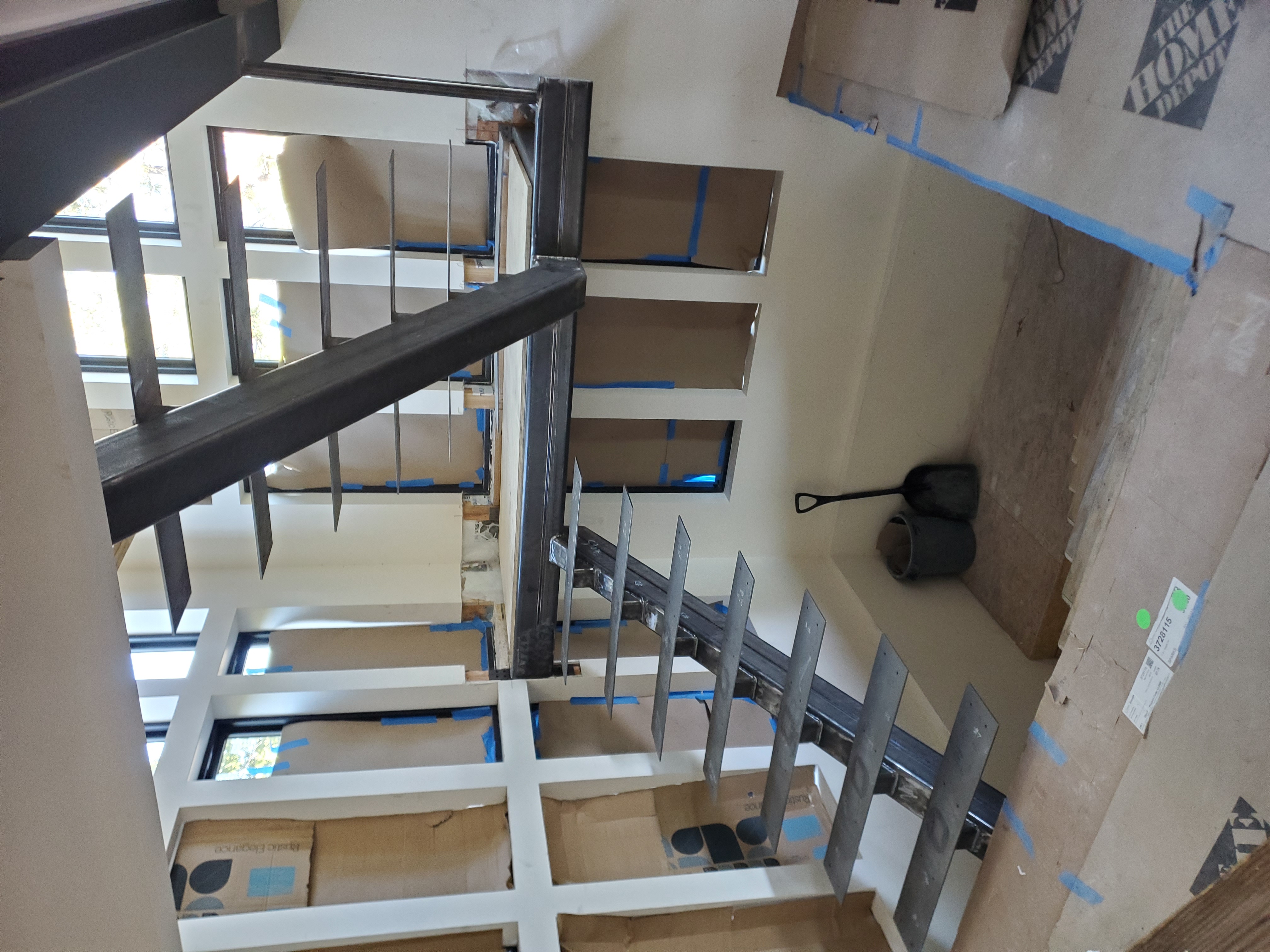 Custom steel stair stringer and landing being installed on site at Bogowolski Residence