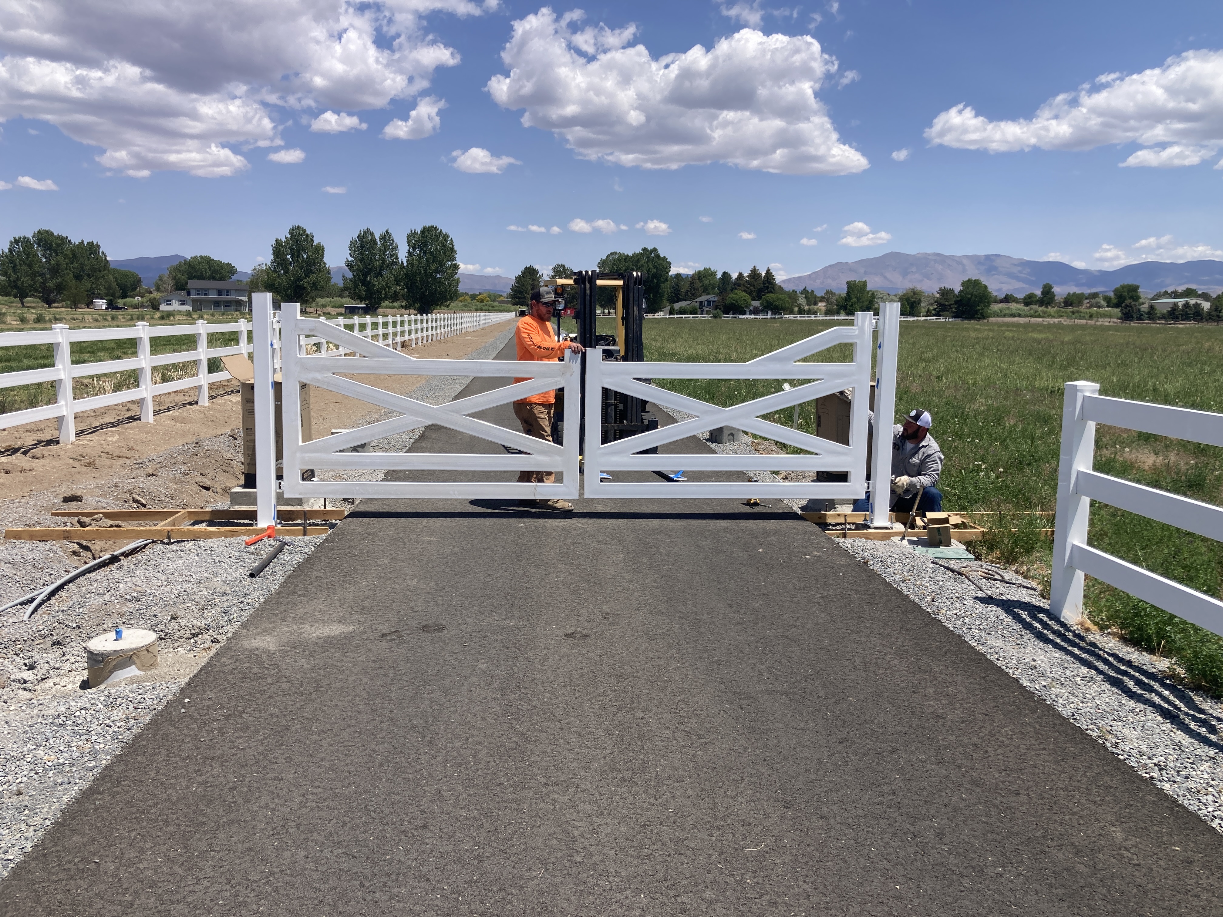 Custom white ranch-style driveway gates fabricated and installed by Battle Born Welding in Carson Valley, NV